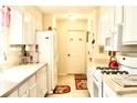 Galley kitchen featuring white appliances, white cabinets and an open space at 150 Ashley Dr, Fayetteville, GA 30214