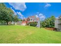 Beautifully landscaped front yard featuring a charming two-story brick home with an attached garage at 3961 S River Ln, Ellenwood, GA 30294