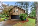 Side view of home showcasing an attached garage and unique wood siding at 490 Hunters Glen Ct, Lawrenceville, GA 30044