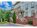Multi-story townhome with brick facade, white railings, and green landscaping in a desirable neighborhood at 2107 Se Gorman Se Grv # 132, Atlanta, GA 30316