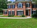 Attractive two-story brick home with black shutters, an arched doorway, and lush green lawn at 4221 Bretdale Nw Run, Kennesaw, GA 30152