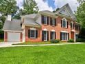 Charming brick two-story home featuring black shutters, well-manicured landscaping, and an attached garage at 4221 Bretdale Nw Run, Kennesaw, GA 30152
