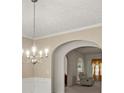 Open concept dining room with decorative chandelier and arched entry into an adjacent seating area at 802 Cormac Dr, Riverdale, GA 30296