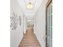 Bright hallway featuring hardwood floors, elegant lighting, and decorative wall art at 427 Bluffs View Ln, Canton, GA 30114