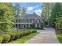 Stately brick home with a well-maintained lawn, mature trees, and a charming fence at 8935 Muirfield Ct, Duluth, GA 30097