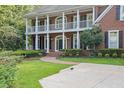 Charming brick home featuring a covered front porch, well-kept lawn, and decorative landscaping at 8935 Muirfield Ct, Duluth, GA 30097