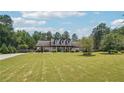 Beautiful home with a large front lawn, complemented by mature trees and a long driveway at 1369 Sierra Ridge Pl, Loganville, GA 30052