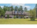 Inviting home showcases a well-manicured lawn, dormer windows and a long porch with column supports at 1369 Sierra Ridge Pl, Loganville, GA 30052