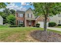 Charming two-story home featuring a brick facade, attached two-car garage, and well-manicured lawn at 2421 Fall Creek Lndg, Loganville, GA 30052