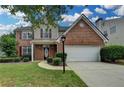 Charming two-story home featuring a brick facade, attached two-car garage, and well-manicured lawn at 2421 Fall Creek Lndg, Loganville, GA 30052
