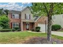 Charming two-story home featuring a brick facade, attached two-car garage, and well-manicured lawn at 2421 Fall Creek Lndg, Loganville, GA 30052