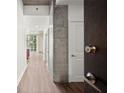 Hallway with hardwood floors and concrete accent wall seen through open door at 855 Peachtree Ne St # 2205, Atlanta, GA 30308