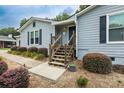 Inviting front entrance with wooden steps and black shutters, enhancing curb appeal at 2711 Bluffton Rd, Buford, GA 30519