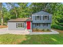 Inviting two-story home featuring gray siding, black shutters, and a striking red front door at 4339 Rushmore Pl, Forest Park, GA 30297