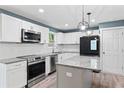 Modern kitchen with stainless appliances, granite countertops, white cabinets, and wood flooring at 4339 Rushmore Pl, Forest Park, GA 30297