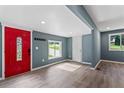 Bright, open-concept living room featuring gray walls, wood flooring, and a red front door at 4339 Rushmore Pl, Forest Park, GA 30297