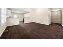Spacious living room with dark carpet and an open layout to the kitchen at 5718 Hidden Brook Cir, Atlanta, GA 30349