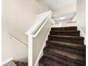 Carpeted staircase with white railing leading to the upper level of the home at 5718 Hidden Brook Cir, Atlanta, GA 30349
