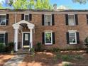 Exterior of a brick multi-Gathering home showcasing the columned entrance with a black front door at 6700 Roswell Rd # 11B, Atlanta, GA 30328