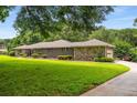 Brick and stone home with manicured lawn, long driveway and mature trees at 1535 Pathfinder Sw Way, Lilburn, GA 30047