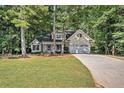 Charming home with a well-manicured lawn and lush greenery, featuring a two-car garage and inviting front porch at 2130 Hampton Se Trl, Conyers, GA 30013