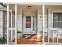 Inviting front porch with decorative columns, potted plants, and a patterned welcome mat leading to the front door at 2130 Hampton Se Trl, Conyers, GA 30013