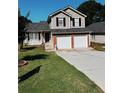 Inviting home featuring a well-maintained lawn and a spacious two-car garage at 2315 Oakland Spring Dr, Snellville, GA 30039