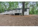Side view of a home showing a ramp entrance, deck, and natural backdrop with mature tree at 343 Compton Rd, Rockmart, GA 30153