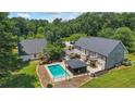 Expansive backyard with a sparkling pool, cabana, detached garage, and lush greenery at 3906 Laurens Ln, Snellville, GA 30039