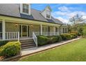 Inviting home featuring a covered front porch, well-kept landscaping, and brick facade at 3906 Laurens Ln, Snellville, GA 30039