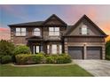 Inviting home features a manicured front yard, brick facade, and two-car garage at 4249 Caveat Ct, Fairburn, GA 30213