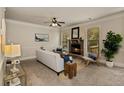 Cozy living room features a stone fireplace, neutral decor, and a ceiling fan at 4249 Caveat Ct, Fairburn, GA 30213