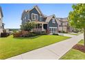 Charming two-story home featuring a well-manicured lawn and lush landscaping with blue siding and a welcoming porch at 326 Still Pine Bnd, Smyrna, GA 30082