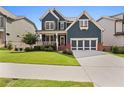 Charming two-story home with blue siding, a well-manicured lawn, and a two-car garage at 326 Still Pine Bnd, Smyrna, GA 30082