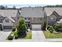 Stunning two-story home boasting a stone and siding exterior, a two-car garage, and neatly landscaped front yard at 4452 Thach Ave, Sugar Hill, GA 30518