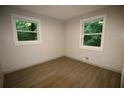 Cozy bedroom showcasing two windows providing natural light, paired with modern hardwood flooring at 2926 Monterey Dr, Decatur, GA 30032