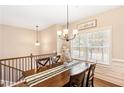 Elegant dining room featuring a wooden table set, chandelier, and bright window at 275 Cedars, Villa Rica, GA 30180