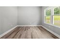 A gray bedroom with wood flooring and a view of the outside at 5341 Stewart Mill Rd, Douglasville, GA 30135