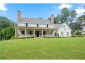 Expansive front yard of charming two-story home with a covered porch and classic rocking chairs at 104 Trinity Hollow Dr, Canton, GA 30115