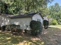 Exterior of the home showcasing the side yard with simple landscaping and privacy shrubs at 512 Rockborough Ter, Stone Mountain, GA 30083