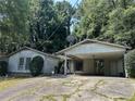 Single-story home with a covered carport featuring mature trees and a concrete driveway at 512 Rockborough Ter, Stone Mountain, GA 30083