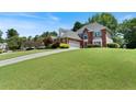 Spacious brick home on a grassy lot with a long driveway to the garage at 3820 Ridge Point Dr, Suwanee, GA 30024