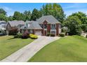 Beautiful brick home with mature trees, well-manicured lawn, and a driveway at 3820 Ridge Point Dr, Suwanee, GA 30024
