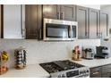 Close-up view of the modern kitchen with stainless steel appliances and a mosaic tile backsplash at 949 Tumlin Trce, Lawrenceville, GA 30045