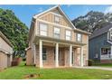 Inviting two-story home with a covered porch, showcasing its well-manicured lawn and classic design at 1777 Meadow Sw Ln, Atlanta, GA 30315