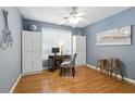 Bedroom area with blue walls, hardwood floors, storage cabinets, a work space and natural lighting at 2995 Ivy Mill Dr, Buford, GA 30519
