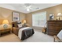 Cozy carpeted bedroom with neutral walls, ceiling fan, and bright window providing natural light at 2995 Ivy Mill Dr, Buford, GA 30519
