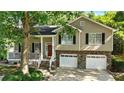 Traditional two-story home features a two-car garage and covered porch with brick and siding at 2995 Ivy Mill Dr, Buford, GA 30519