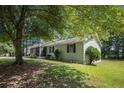 Exterior view of the home showing the side yard, screened porch, and surrounding mature trees at 2780 Highpoint Rd, Snellville, GA 30078