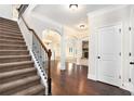 Elegant foyer with hardwood floors, staircase, and archways leading to open living spaces at 5689 Woodland Greens Rd, Douglasville, GA 30135